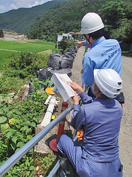 豪雨災害の後の道路の現地調査（奥が筆者）